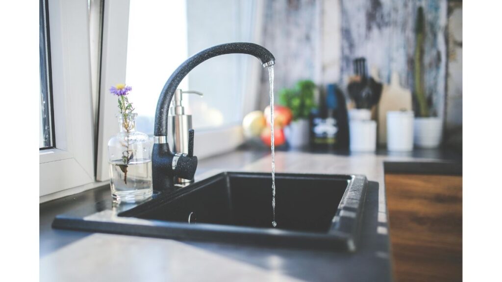 Water flowing from a household faucet into a clear glass